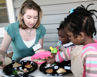 HPDP researcher working with two kids on healthy eating workshop
