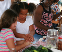Two girls participate in a pickling event