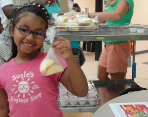 Girl holds apple in Food Explorers school program