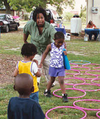 Woman playing with children using hula hoops