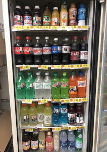 A beverage cooler filled with soda, juice and water.
